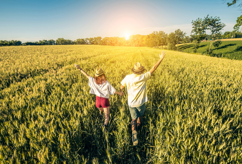 Loving couple running in a wheat field.
